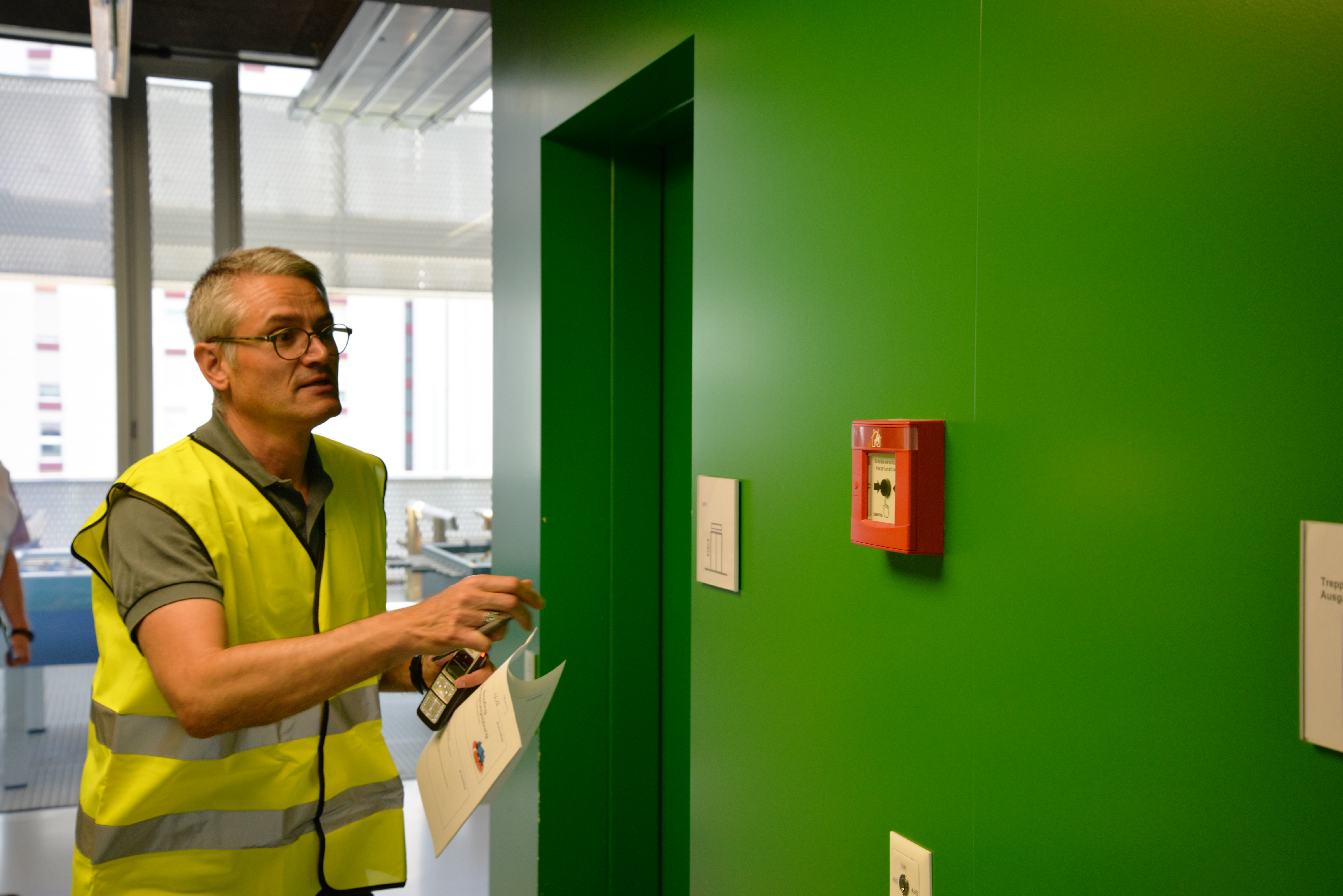 ein Evakuierungshelfer löst den Brandalarm aus.