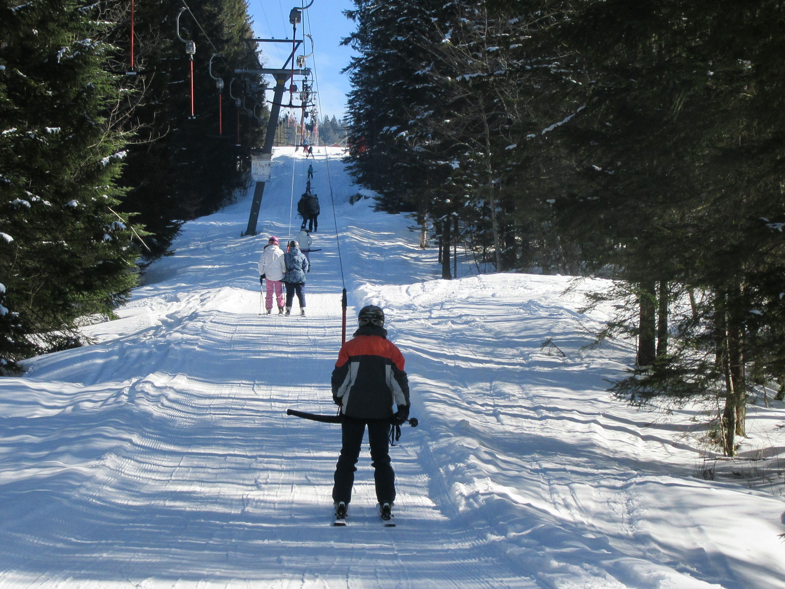 Skifahrer auf dem Bügellift in der Ibergeregg bei herrlichem Wetter